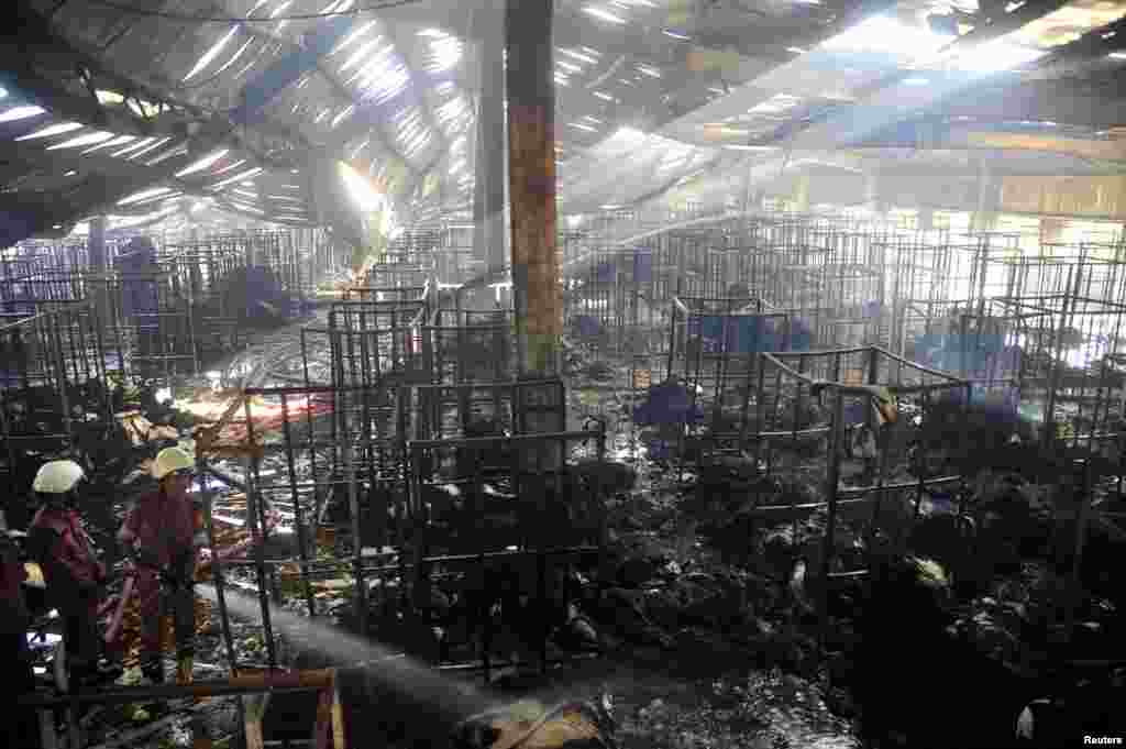 Firefighters try to control a fire in a garment factory in Gazipur, Bangladesh, Oct. 9, 2013.