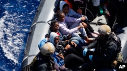 Des migrants secourus et embarqués dans un canot gonflable lors de l’opération Sophia, au large de la côte libyenne, en Méditerranée, 29 mars 2016.