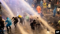 Para demonstran pro demokrasi basah kuyup setelah terkena semprotan meriam air ketika polisi anti huru-hara berusaha membubarkan aksi protes anti-pemerintah di Bangkok, Thailand hari Jumat (16/10).