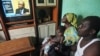 Adama Fofana, who says two of his brothers were killed in post-election violence and their bodies dumped in a mass grave, watches the televised trial of former Ivorian President Laurent Gbagbo, Feb. 19, 2013. 