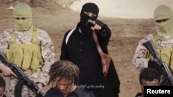 Militan ISIS memegang senjata dan berdiri di belakang apa yang disebut umat Kristen Ethiopia di Wilayat Fazzan, di foto yang berasal dari video tanpa tanggal yang tersedia di media sosial pada 19 April 2015. 