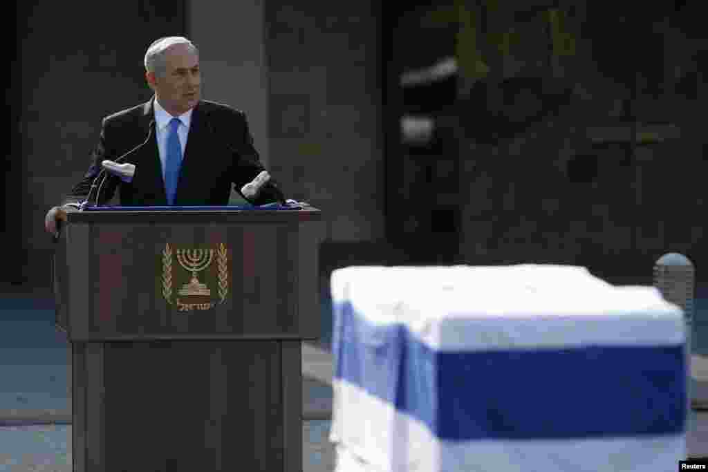 Israel's Prime Minister Benjamin Netanyahu speaks near the flag draped coffin of former Prime Minister Ariel Sharon during a memorial ceremony at Israel's parliament in Jerusalem, Jan. 13, 2014.