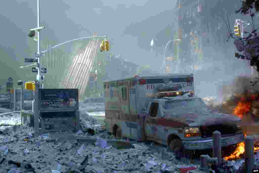 (FILE) An ambulance, covered with debris, is on fire after the collapse of the first World Trade Center Tower 11 September, 2001 in New York. Two hijacked passenger planes were crashed against the twin towers causing the collapsed of both buildings. AFP PHOTO Doug KANTER (Photo by DOUG KANTER / AFP)