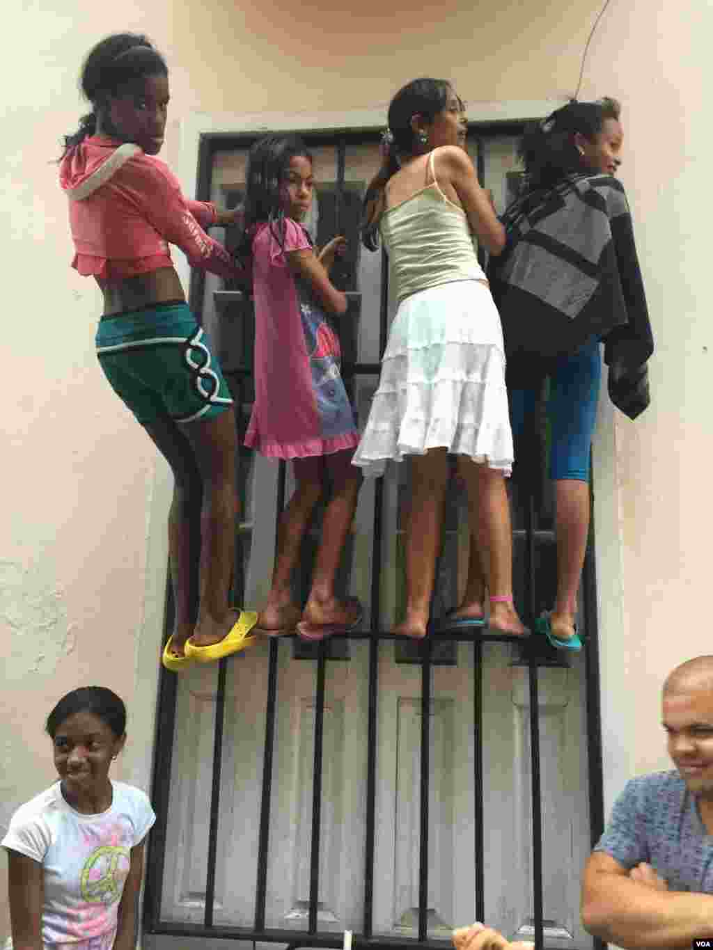 Cubans wait in the rain to catch a glimpse of U.S. President Barack Obama in Havana, Cuba. (V. Macchi / VOA)
