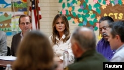 La primera dama de EE.UU., Melania Trump y el secretario de Salud y Servicios Humanos, Alex Azar (izquierda), escuchan a funcionarios de servicios sociales del Centro para niños Upbring New Hope, de la iglesia luterana para el sur de EE.UU., durante una visita sorpresa a la instalación que alberga a niños migrantes detenidos en la frontera.