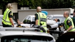 Para petugas ambulans membawa keluar seorang pria dari sebuah masjid di pusat Kota Christchurch, Selandia Baru, 15 Maret 2019. 