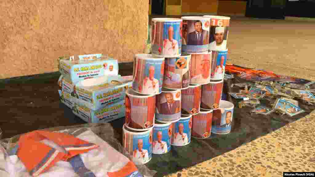 Des gadgets de campagne électorale à l'effigie de Hama Amadou, candidat du Moden Lumana, étalés devant le siege du parti à Niamey, Niger, 16 février 2016. (VOA/Nicolas Pinault)