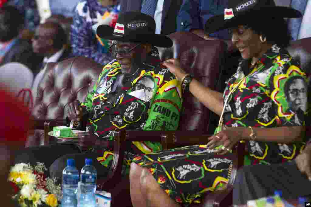 Grace, la femme du président zimbabwéen Robert Mugabe, à droite, tient l’épaule gauche de son mari qui célèbre ses 93 ans d'anniversaire à Matopos, dans la banlieue de Bulawayo, 25 février 2017.