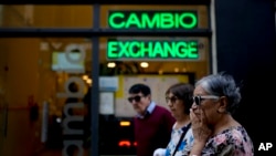 Sejumlah warga berjalan melewati tempat penukaran uang di Buenos Aires, Argentina, pada 10 Oktober 2023. (Foto: AP/Natacha Pisarenko)