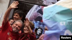 FILE - Brazil's President and Workers' Party (PT) presidential candidate Dilma Rousseff (R) and her predecessor Luiz Inacio Lula da Silva wave to supporters during a campaign rally in Sao Paulo, Oct. 3, 2014.