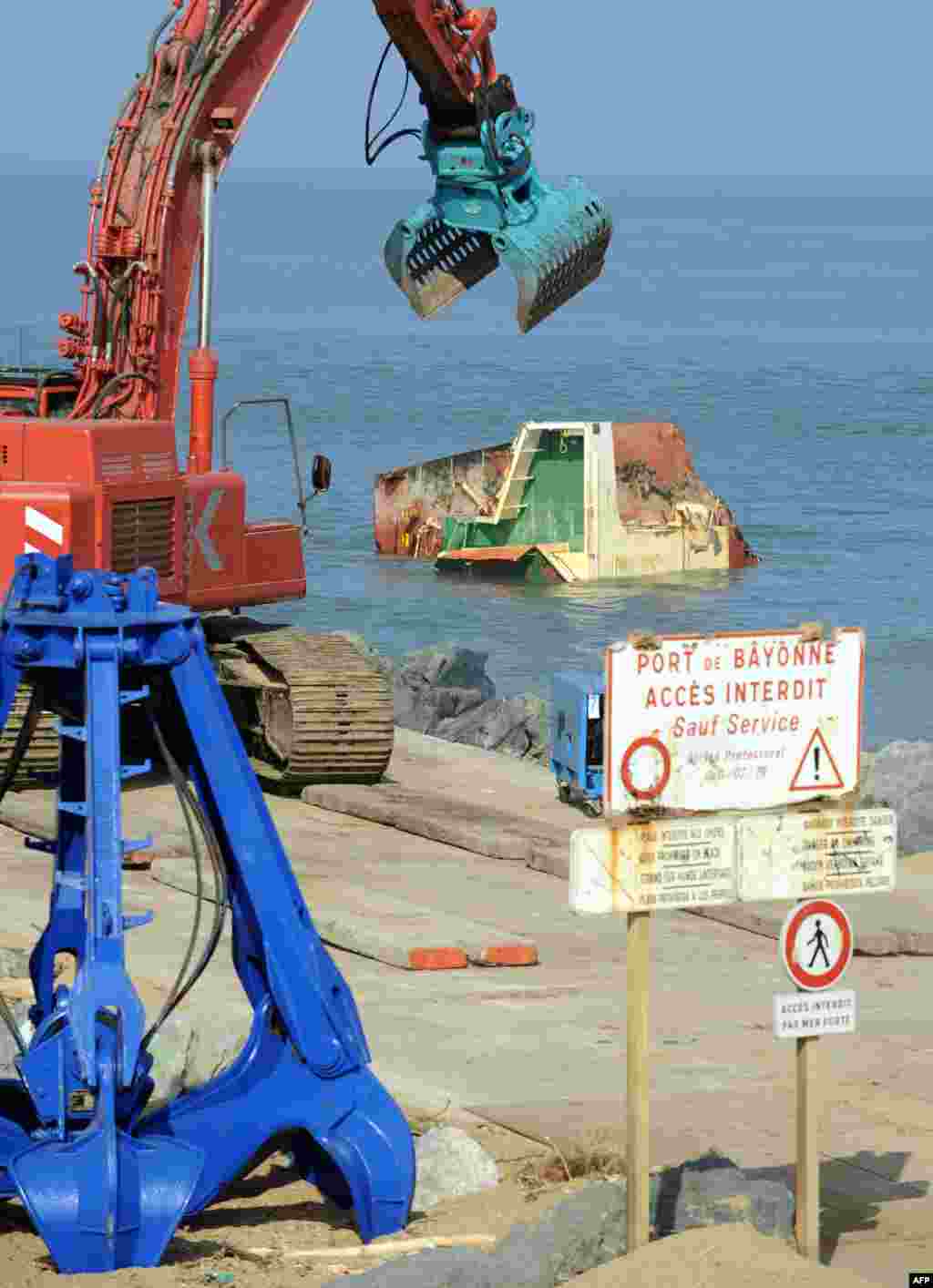 Picture shows cranes and part of the wreckage of the Spanish cargo ship 'Luno' in Anglet, southwestern France, during the dismantling of the ship which broke into three sections after a shipwreck in February 2014. The 20-year-old Spanish vessel split in two when winds and waves smashed it up against an artificial breakwater on February 5. The crew of 11 were rescued by helicopter in perilous conditions.