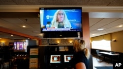 Une serveuse regarde un briefing télévisé du Dr Rachel Levine, secrétaire d'État à la santé de Pennsylvanie, au restaurant Penrose Diner, le 17 novembre 2020, dans le sud de Philadelphie.