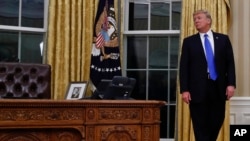 President Donald Trump pauses during a ceremony in Oval Office of the White House in Washington, Wednesday, Feb. 1, 2017, for the swearing in ceremony of Rex Tillerson as Secretary of State. (AP Photo/Carolyn Kaster)