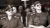 বাশার আল-আসাদ (ডানে) প্রেসিডেন্ট মনোনীত হবার পর সিরিয়ার সেনাপ্রধান জেনেরাল আলি এসলানের সাথে সামরিক মহড়া দেখছেন। ফাইল ফটোঃ ১২ জুলাই, ২০০০। 