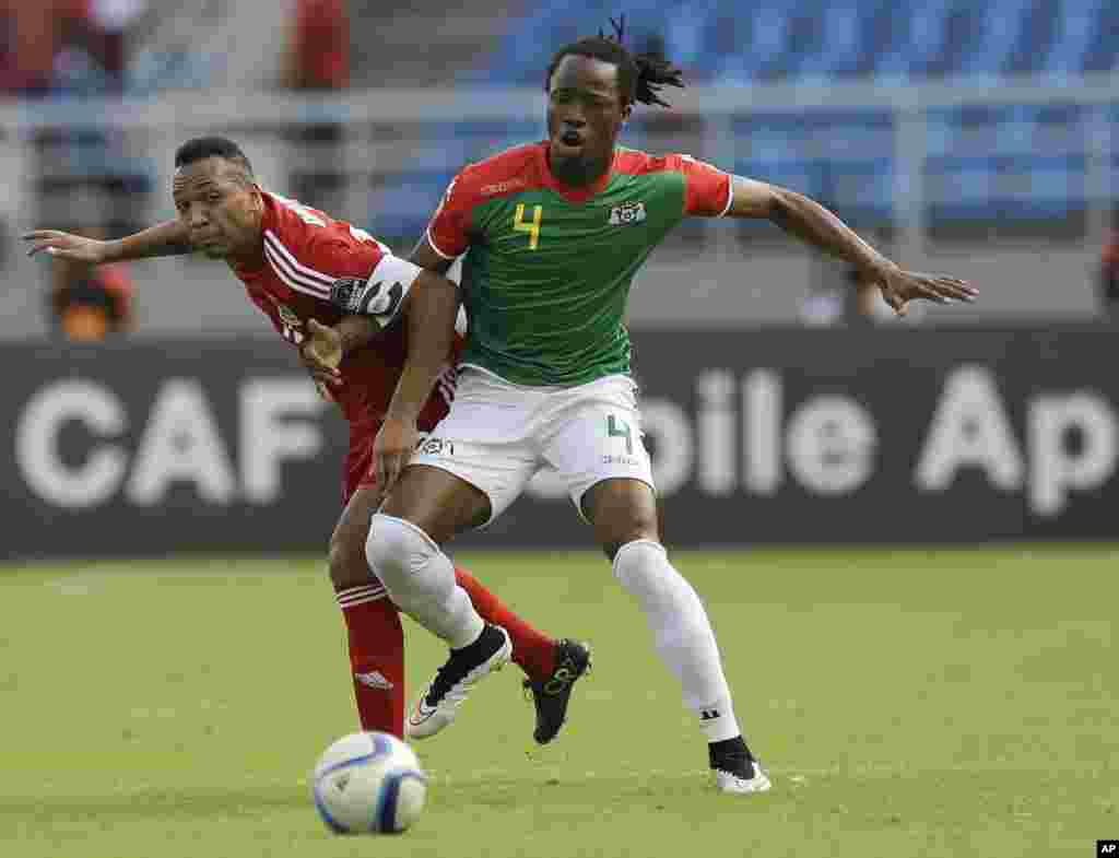 Bakary Koné du Burkina Faso, à droite, aux prises avec Emilio Nsue de la la Guinée équatoriale, à gauche, lors de la rencontre Burkina Faso-Guinée équatoriale de la Coupe d'Afrique des Nations Groupe A à Bata, en Guinée équatoriale, mercredi 21 janvier 2015.