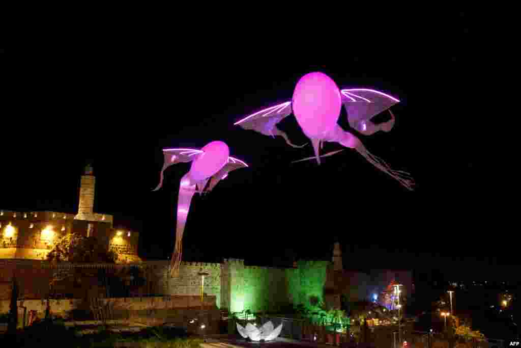 Two light installations shaped as fish hoover over Jerusalem's old city ancient walls during the Jerusalem Festival of Lights, June 4, 2013.