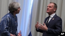 FILE - European Union Council President Donald Tusk (R) speaks with British Prime Minister Theresa May during a bilateral meeting on the sidelines of a summit of EU and Arab leaders at the Sharm El Sheikh, Egypt, Feb. 24, 2019. 