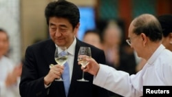 Japan's Prime Minister Shinzo Abe (L) and Burma's President Thein Sein toast during lunch at the Myanmar International Convention Center in Naypyitaw, May 26, 2013.