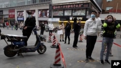Warga dengan mengenakan masker antri untuk memasuki supermarket di Wuhan, Hubei, China, Jumat (3/4). Kota Wuhan adalah kota di mana kasus pertama Covid-19 diketahui. 