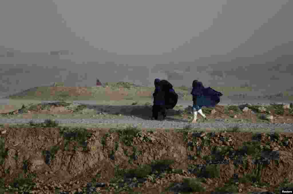 Women walk on a windy day outside Kabul, Afghanistan.