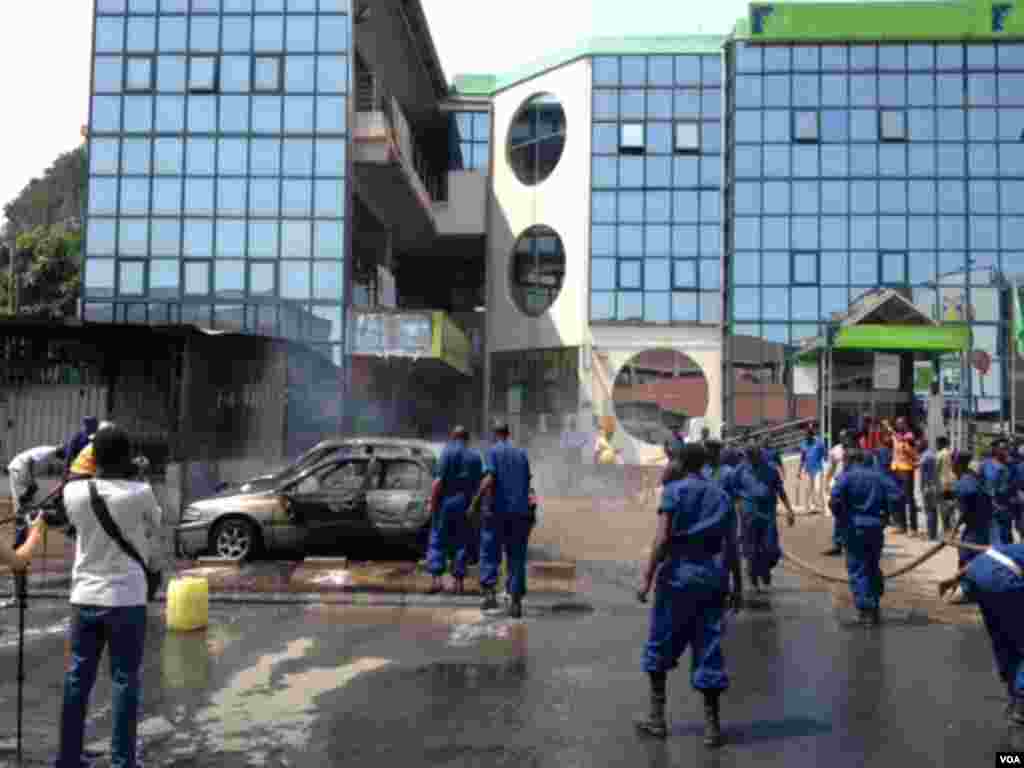 Trois véhicules endommagés et partiellement incendiés suite à l'explosion d'une grenade près de la Banque commerciale du Kenya à Bujumbura, Burundi vendredi 29 mai 2015. (Edward Rwena - VOA)