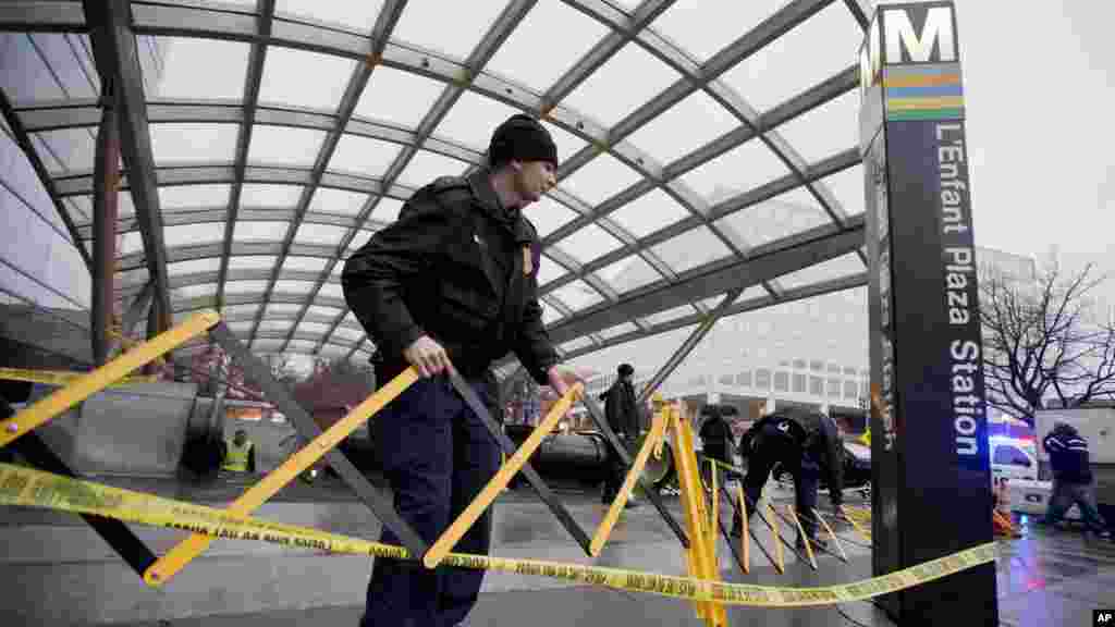 Des agents de la Police Metro Transit sécurisent l'entrée de la station L'Enfant Plaza à Washington, lundi 12 janvier 2015, à la suite d'une évacuation.