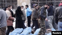 Des combattants de l'Armée syrienne libre et les habitants tentent d'identifier les corps trouvés le long d'une rivière, dans une école utilisée comme un hôpital de campagne à Bustan al-Qasr d'Alep, 29 janvier 2013. 