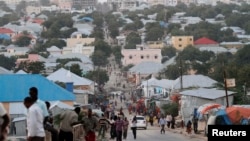 FILE - People walk along a street in Mogadishu, Somalia, Sept. 28, 2013. 