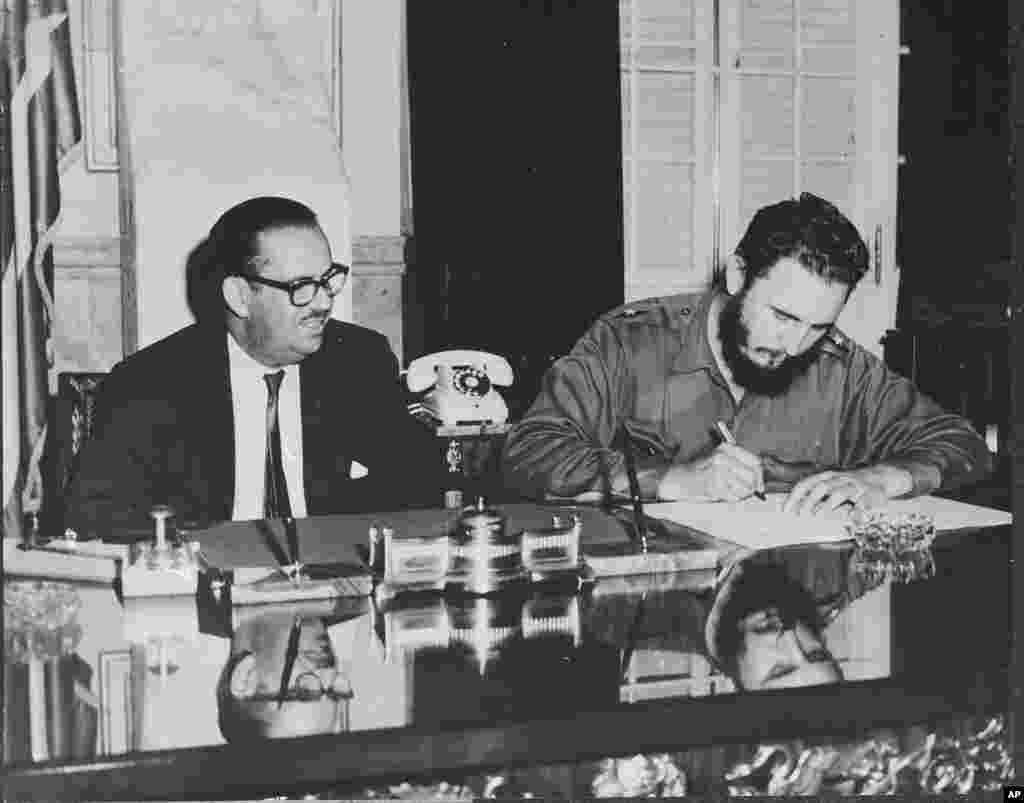 Fidel Castro, alors Premier ministre, signe un décret nationalisant toutes les banques américaines à Cuba, le 17 septembre 1960. &nbsp;