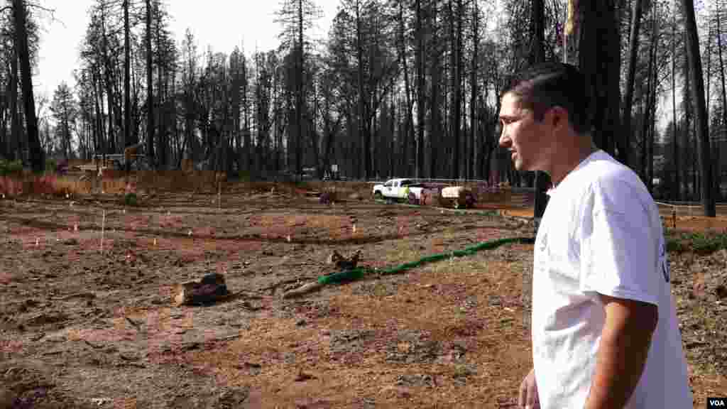 Valentin Martinez looks at what the remains of his home, where he lived with his wife and son. Fleeing the fire, he was able to save a few things: his mother's and father-in-law's ashes and a few photos.(Elizabeth Lee/VOA News)