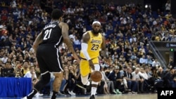 LeBron James, à droite, face à Wilson Chandler lors d'un match de pré-saison entre les LA Lakers et les Brooklyn Nets à Shanghai, Chine, le 10 octobre 2019.