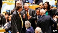 Duta Besar Belanda untuk PBB Karel van Oosterom (tengah) berbicara dengan Menteri Luar Negeri Italia Paolo Gentiloni (duduk, tengah), disaksikan Menteri Luar Negeri Belanda Bert Koenders (kiri) dan Duta Besar Italia untuk PBB Sebastiano Cardi (kanan) dalam sidang Dewan Keamanan PBB di New York (28/6). (AFP/Kena Betancur)