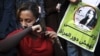 An Egyptian woman cuts her hair during a demonstration in Tahrir Square, Cairo, Egypt, Tuesday, Dec. 25, 2012.