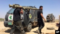 Les forces antiterroristes irakiennes réparent leurs véhicules blindés lors d'une pause durant les combats à proximité de Falloujah, en Irak, le 31 mai 2016.