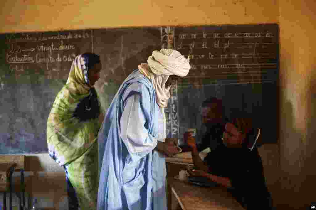 A Tamacheq man has his finger dyed with ink after casting his ballot in Mali's parliamentary elections in Gao, Nov. 24, 2013.