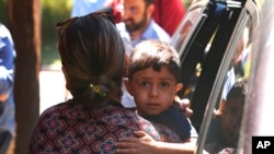 Un niño de Honduras es traído a la oficina de Inmigración y Control de Aduanas en Grand Rapids, Mich., July 10, 2018. Un juez ha ordenado la suspensión de las deportaciones de familias migrantes separadas en la frontera sur de EE.UU.