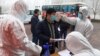 Seorang pekerja migran menjalani pemeriksaan suhu di sebuah pabrik di Zouping, di Provinsi Shandong China, 25 Februari 2020. (Foto: AFP)