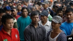 Para nelayan dari Burman menanti keberangkatan kapal yang akan membawa mereka meninggalkan Pusaka Benjina di Kepulauan Aru, 3 April 2015.