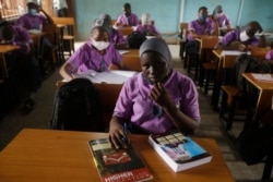FILE - Students from Oregun Junior and Senior High School, wearing face mask to protect against coronavirus attend lectures inside a class room in Lagos, Nigeria, Jan. 18, 2021.
