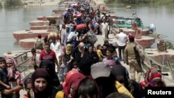 Para pengungsi Muslim Sunni Irak yang meninggalkan kota Ramadi menyeberangi jembatan dan berusaha masuk ke kota Baghdad, Minggu (24/5).