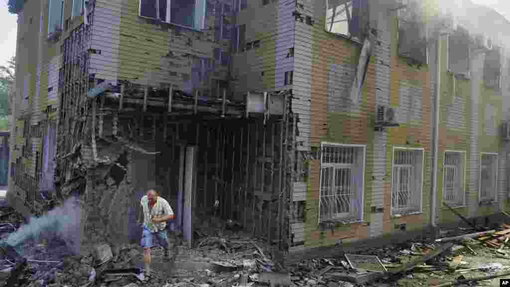 A man runs out of the destroyed building after shelling in Donetsk, eastern Ukraine, Aug. 10, 2014.