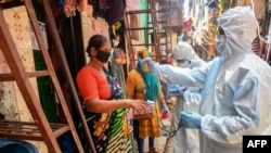 Le personnel médical portant un équipement de protection individuelle (EPI) procède à un examen médical de porte à porte à l'intérieur des bidonvilles de Dharavi pour lutter contre la propagation du coronavirus COVID-19 à Mumbai, le 24 juin 2020. (Photo INDRANIL MUKHERJEE / AFP)