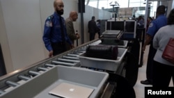 Bagasi dan laptop penumpang diperiksa melalui alat pemindai di bandara JFK, New York (foto: ilustrasi). 