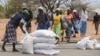 FILE - Zimbabweans collect food aid from a distribution point in Mutawatawa, about 220km northeast of the capital Harare, November 25, 2013. 