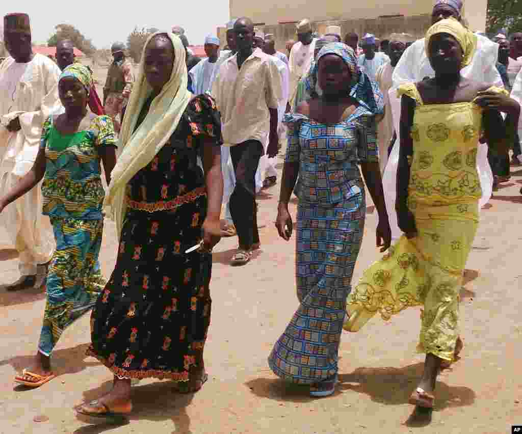 Empat remaja perempuan kembali ke keluarga mereka setelah pria-pria bersenjata menculik lebih dari 200 siswi dari sebuah SMP khusus perempuan di Chibok, Nigeria (21/4). (AP/ Haruna Umar)