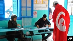 Un électeur tunisien drapé du drapeau national dans un bureau de vote à La Marsa, dans la banlieue de Tunis, le 21 décembre 2014.