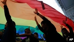 资料照片：2017年11月25日，香港LGBTQ游行参与者举着巨大的彩虹旗。（美联社照片）