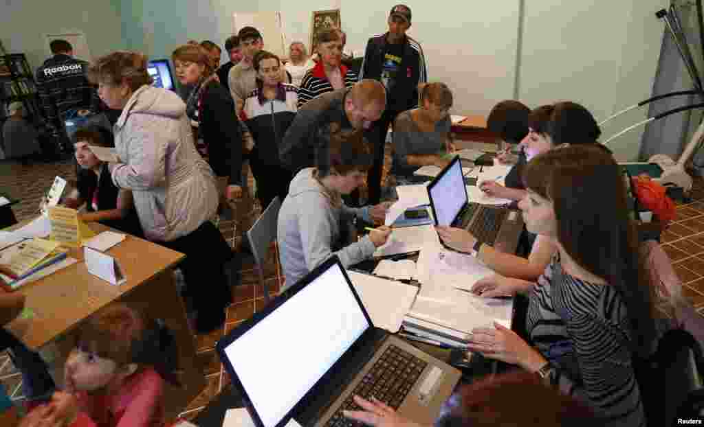 People, who have fled the fighting in the eastern regions of Ukraine, queue for job vacancies at an employment fair at the dormitories where they have taken refuge in Krasnoyarsk Russia, Sept. 2, 2014.