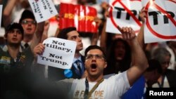 Delegados de Bernie Sanders muestran carteles oponiéndose tanto a Hillary Clinton como a Donald Trump dentro del Centro de Convenciones en Filadelfia.
