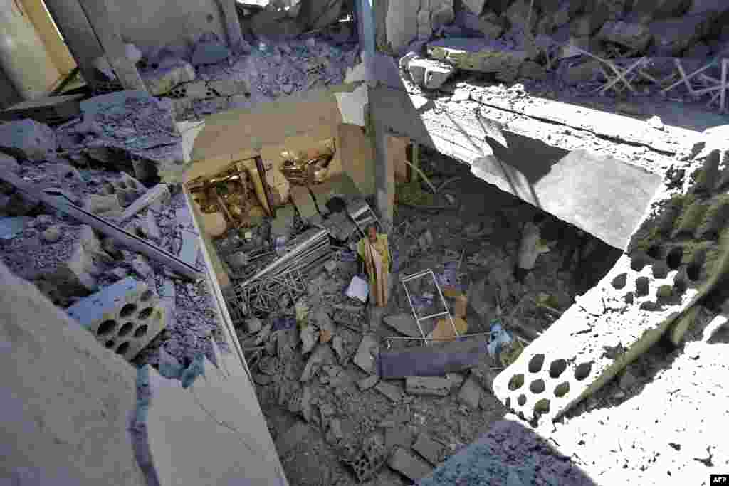 An airport worker walks through the debris of a building destroyed following a reported airstrike by the Saudi-led coalition targeting the Houthi rebel-held Yemeni capital's Sanaa International Airport.